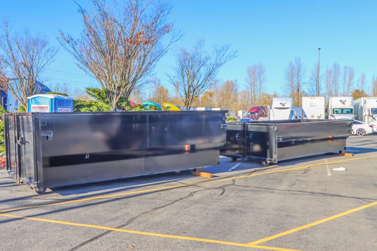 Professional dumpster rental service with roll-off container on residential driveway in Logan